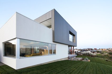 White and Black modern house with large grass field