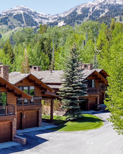 Exterior of luxury homes with mountains in the background.