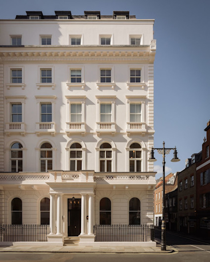 White stucco Mayfair townhouse exterior with classical columns and arched windows, mobile crop, from the Charles Street listing