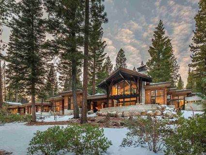large wood cabin surrounded by tall trees