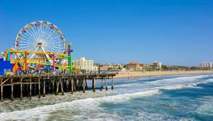 A Ferris wheel and roller coaster are visible near Santa Monica Beach, one of the best beaches for kids on the West Coast.