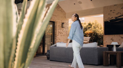 Pacaso owner Noel Hyun Minor walking across the covered patio at Westbourne, a Pacaso home in La Jolla