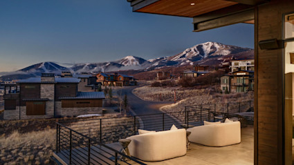 Upper deck with curved white lounge seating and Deer Valley peaks at dusk, desktop crop, Deer Peak listing