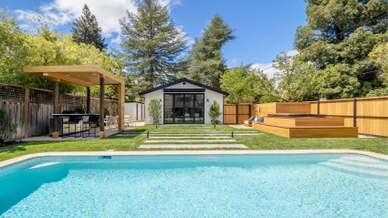 Backyard with pool, hot tub, and outdoor kitchen