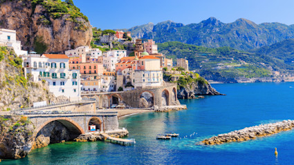 Amalfi Coast with old building built on cliffs against the aquamarine ocean.