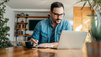 a man sitting at a table with a laptop