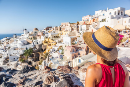 Tourist on vacation looking at Oia village view in Greece. 