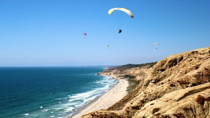 Paragliders over San Diego’s cliffs capture the coastal energy that pairs with a Pacaso home base for active days.