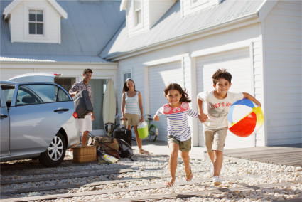 Two kids run for the beach as their parents unload the car at their vacation property, having answered the question for themselves, “Are timeshares worth it?”