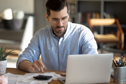 Man looks at laptop screen calculate investment return potential