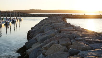 A rocky embankment surrounds a dock at Menemsha Beach, one of the best beaches for kids on the East Coast.