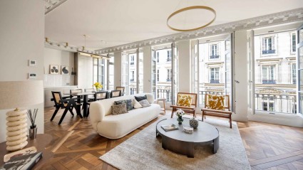 Interior of a Paris vacation home living room featuring a large window and wooden flooring