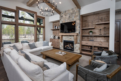 Grand living room at Dancing Rock showcases a stone fireplace, soaring ceiling and gathering-ready layout.