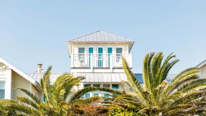 A beautiful timeshare with palm trees in the yard.