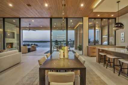 A modern kitchen and dining area overlooking the lake, featuring sleek design and natural light.