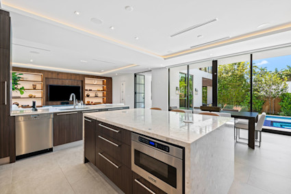 Kitchen at Casa Estrada featuring light stone surfaces and a clean layout that supports minimalist architecture principles for daily living and entertaining in Miami Beach.