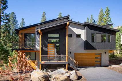 Exterior photo of the front of the Rockrest home with surrounding landscapes and pine trees.