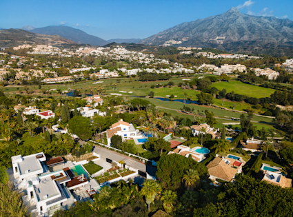 an aerial view of a town with a mountain in the background