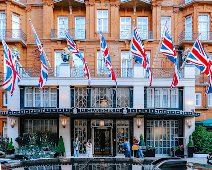 Experience the elegance of London's luxury with Claridge's Hotel, adorned with British flags, classic architecture, and a welcoming atmosphere in the heart of Mayfair.