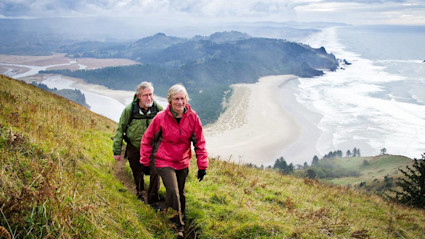 A couple enjoys a coastal hike, one of the many hobbies for empty nesters.
