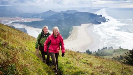 A couple enjoys a coastal hike, one of the many hobbies for empty nesters.