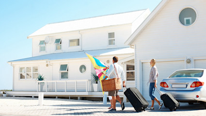 A family walks towards a beach house.