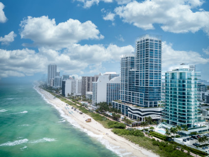 A long ocean beach next to high-rise condos and buildings