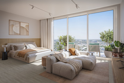 Bright, neutral-toned luxury bedroom with floor-to-ceiling windows, cozy seating, and sweeping city views.