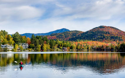 Mountains can be seen in the distance from Lake Placid’s calm waters, one of the best spring break ideas for families.