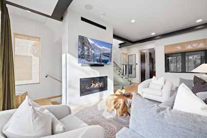 Living room with lofted ceiling and beams, offering a cozy space for family interactions, located at Timberline, Park City