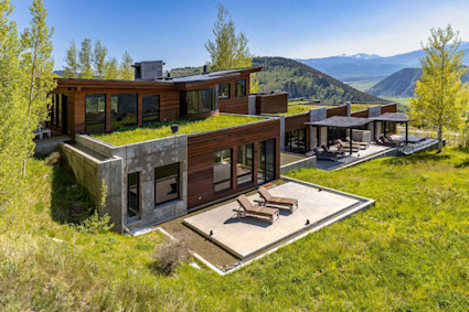 Exterior of Harvest Ridge home with manicured green grass with mountain views.