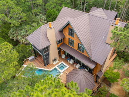 An aerial view of the Blue Heron home on Kiawah Island, showcasing its private pool and secluded setting within a lush, wooded area.