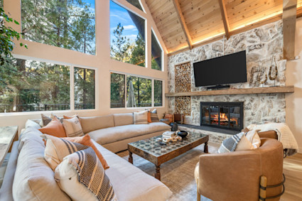 West Shore’s vaulted living room, fireplace and window wall frame calm lake views that define the quiet season in Lake Arrowhead.