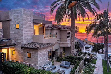 Exterior of Windansea luxury townhome with a vibrantly colored sunset in the background. 