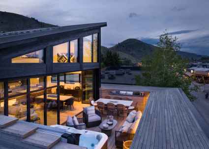 Exterior of a Jackson, WY second home with an outdoor deck during the evening