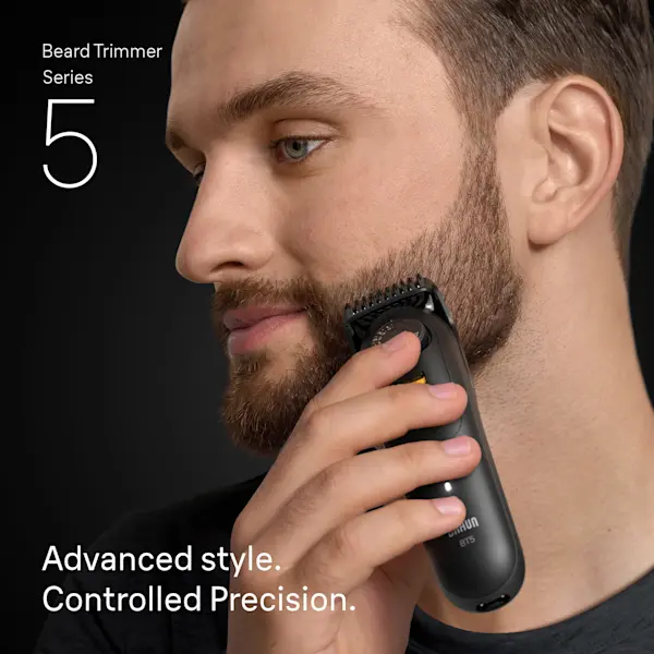 Young man trimming his beard on the side of his face with the Braun Beard Trimmer Series 5