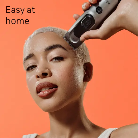 Woman using hairclipper on head