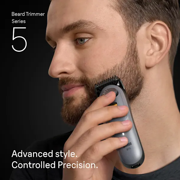 Young man trimming his beard on the side of his face with the Braun Beard Trimmer Series 5