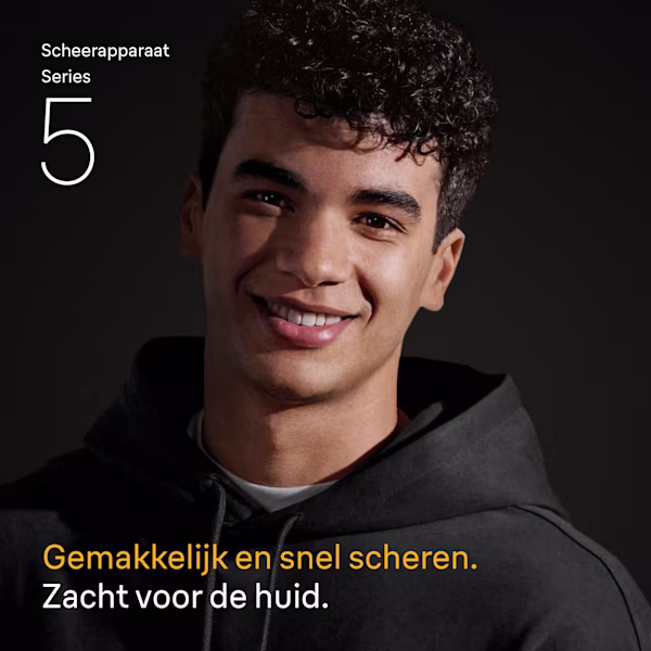 Glimlachende jonge man met krullend zwart haar die een zwarte hoodie draagt. Glimlachende jonge man met krullend zwart haar die een zwarte hoodie draagt.