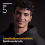 Glimlachende jonge man met krullend zwart haar die een zwarte hoodie draagt. Glimlachende jonge man met krullend zwart haar die een zwarte hoodie draagt.