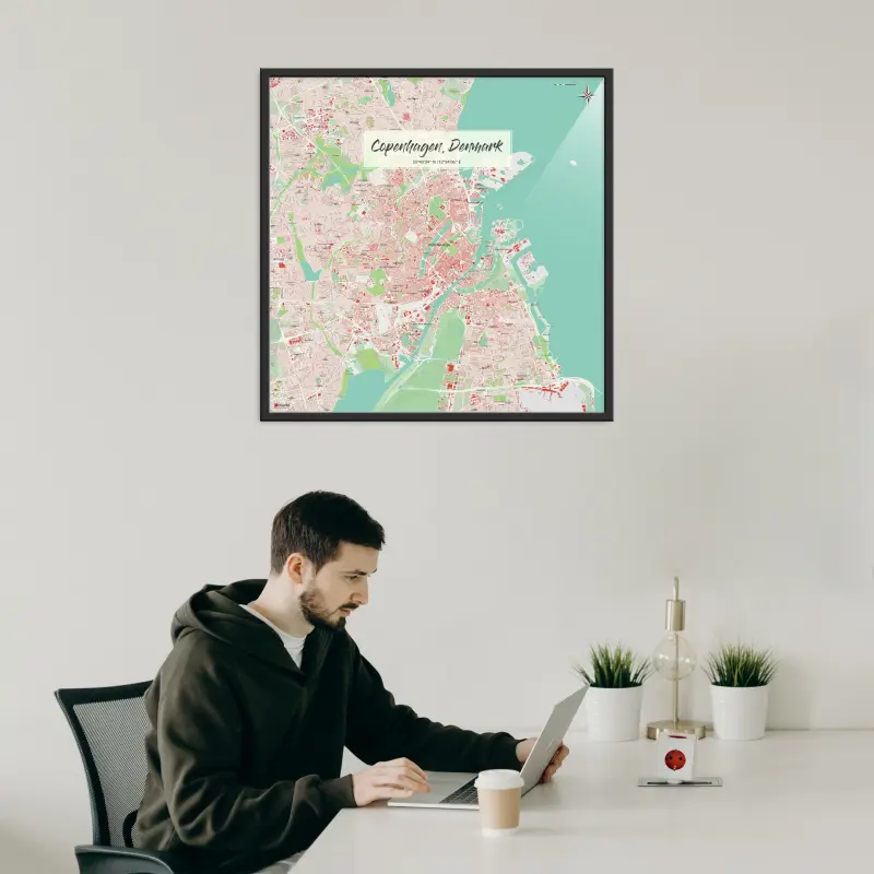 Kopenhagen-Stadtkarte als Poster im Nani Design in einem Büro mit Mann und Laptop