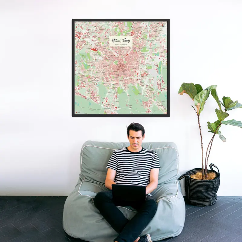 Mailand-Stadtkarte als Poster im Nani Design hinter einem Sessel mit Mann und Laptop