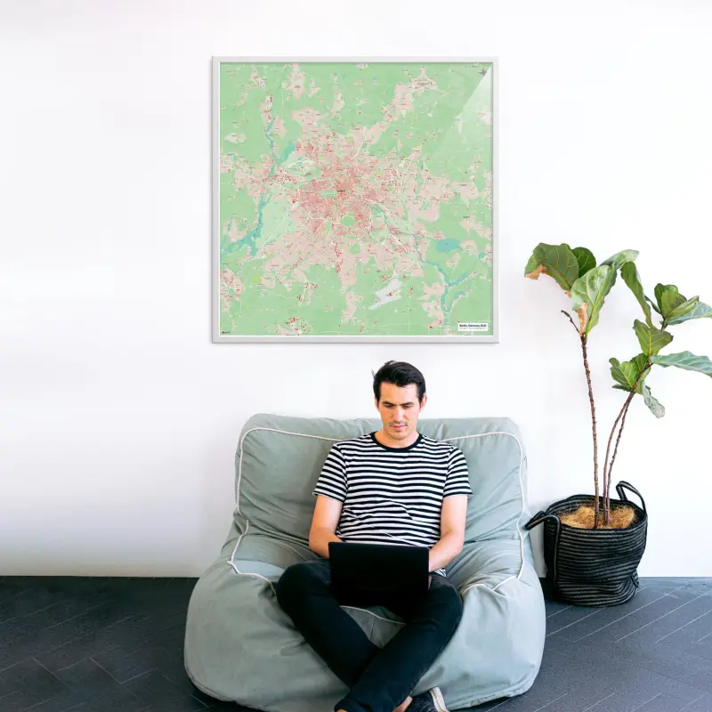 Berlin-Stadtkarte als Poster im Nani Design in einem Wohnzimmer mit Mann und Laptop