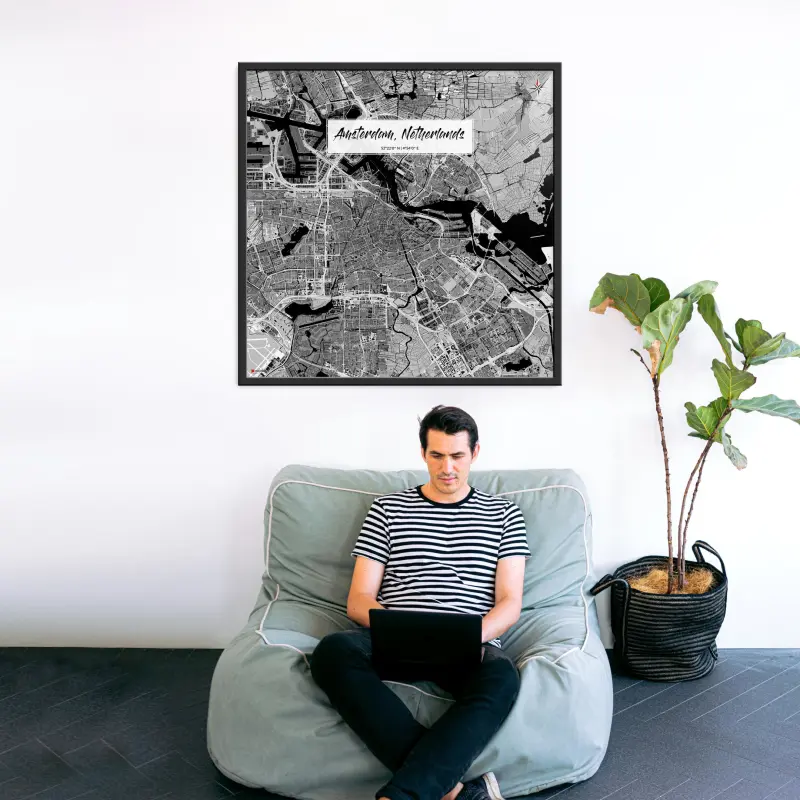 Amsterdam-Stadtkarte als Poster im Kaia Design hinter einer Couch mit Mann und Laptop