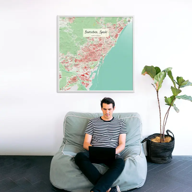Barcelona-Stadtkarte als Poster im Nani Design in einem Wohnzimmer mit Mann und Laptop