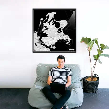 Rügen-Landkarte als Poster im Kaia Design über einem Sessel mit Laptopnutzer