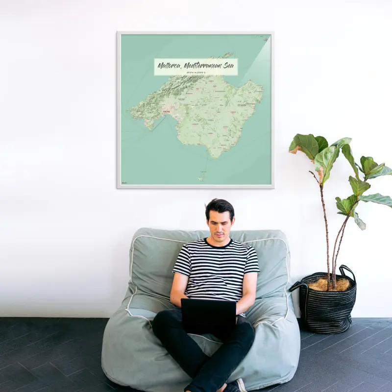 Mallorca-Landkarte als Poster im Nani Design hinter Sessel und Laptopnutzer