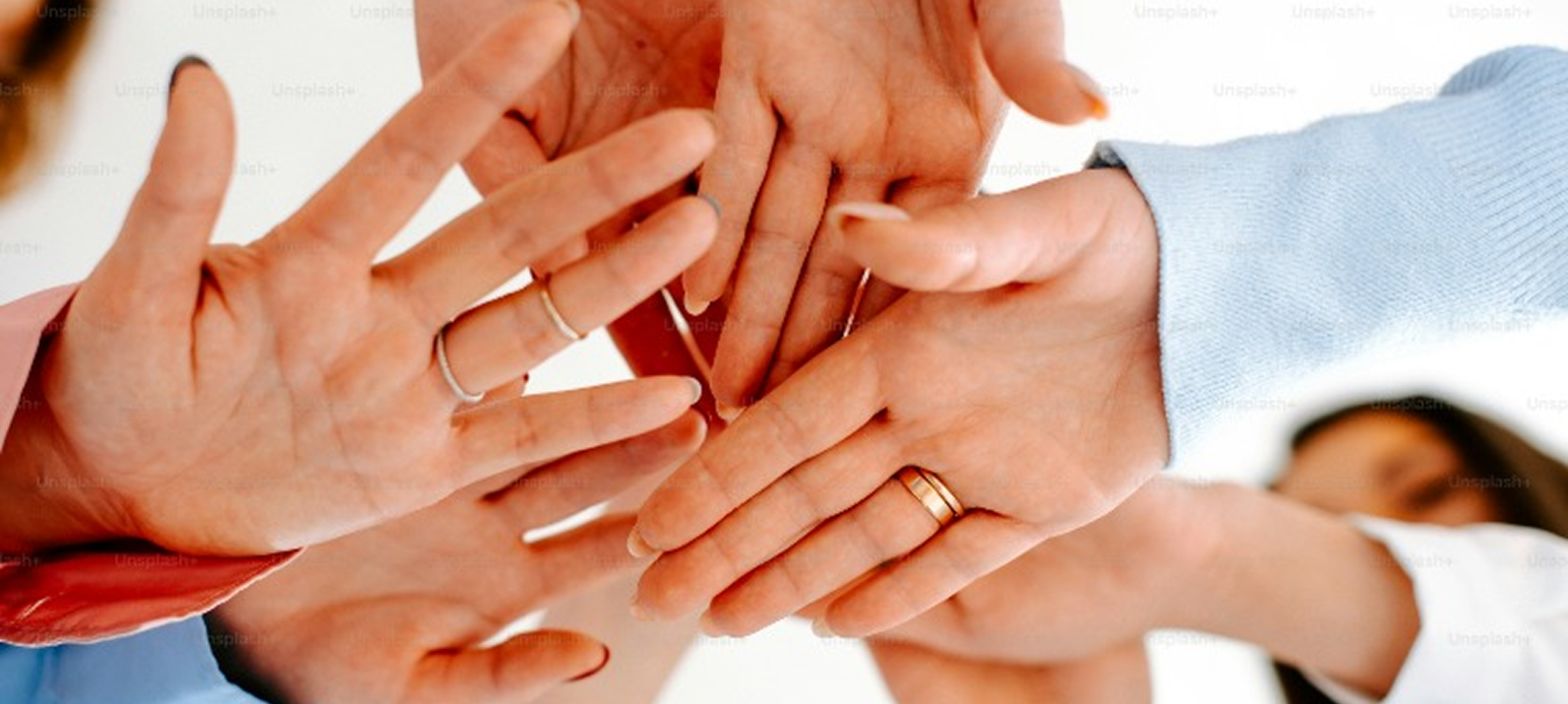 L'immagine mostra alcune mani, appartenenti a persone diverse, sovrapposte l'una all'altra. L'idea concettuale di questa immagine è l'unione di un gruppo.