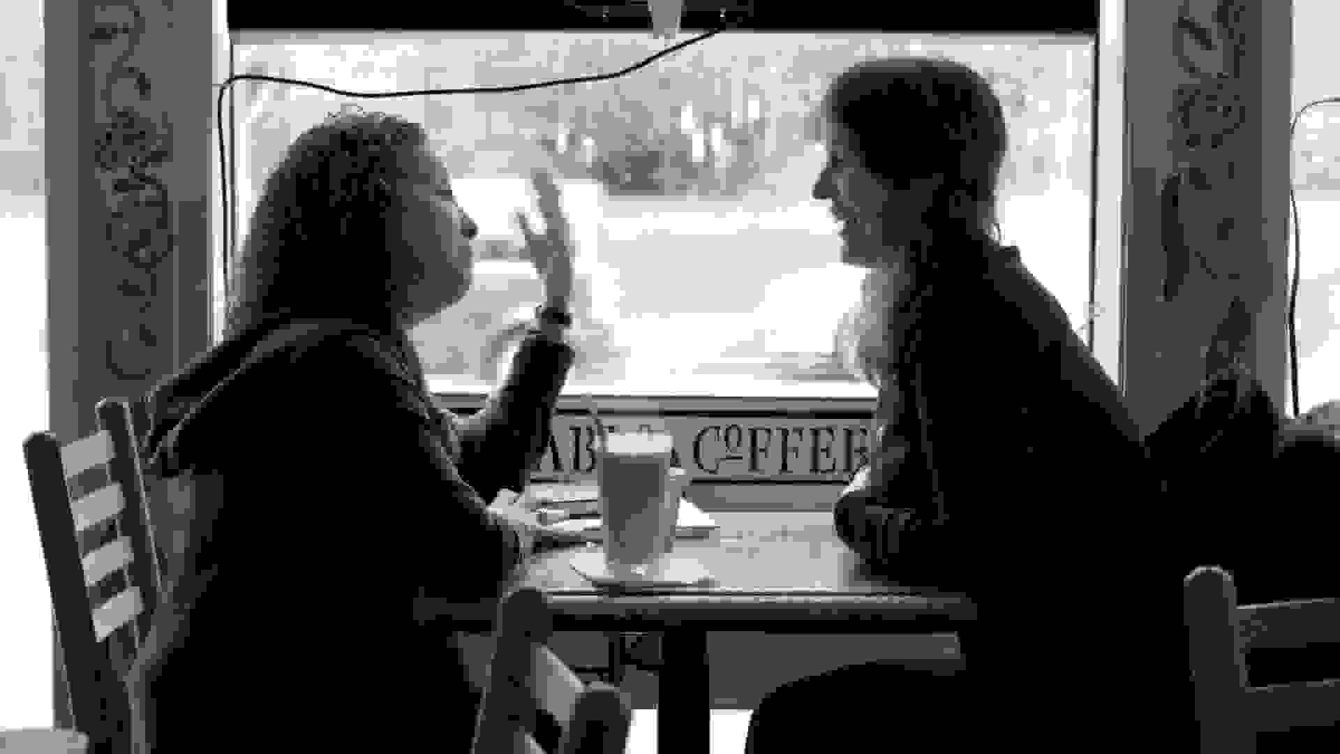 Two people having a conversation in a cafe