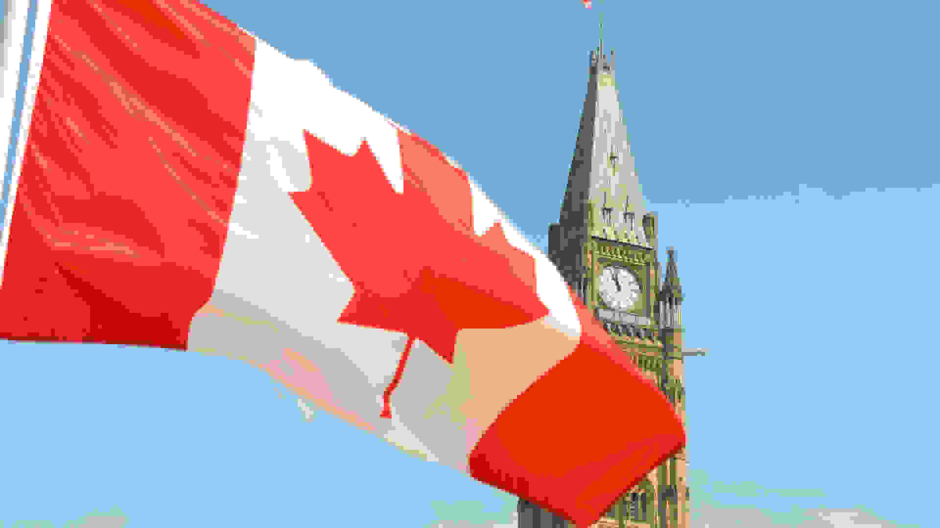 Canadian flag waving in front of the Parliament Building on Parliament Hill in Ottawa | © Jason Hafso